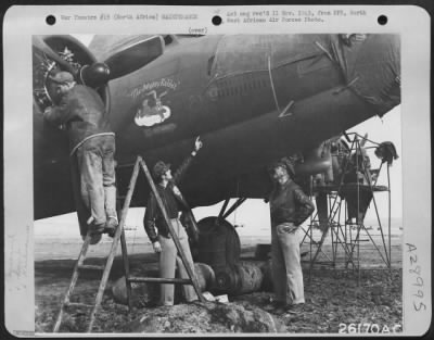 Consolidated > As a member of the ground crew works on an engine of the Boeing B-17 "The Mighty Rabbit," Lts. James and George W. Flathers point with pride to the mission marks painted on the nose of the plane at an air base in Northwest Africa.