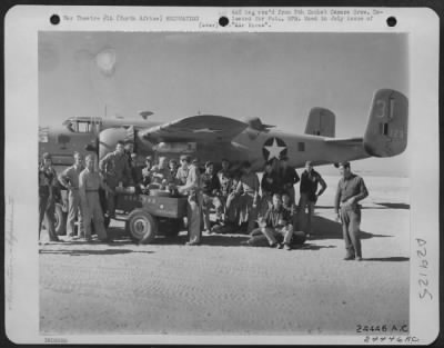 Consolidated > North Africa-Too busy with bombing missions to take advantage of regular messing facilities, members of the Earthquakers bomb group are served coffee and doughnuts beside the plane.