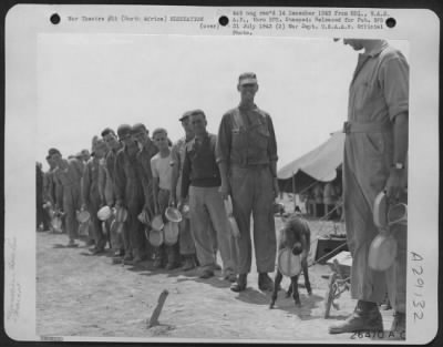 Thumbnail for Consolidated > WITH MAJ. GEN. DOOLITTLE'S STRATEGIC B-25 MITCHELL BOMBERS, NORTH AFRICA. Bergatroid, sad-faced mascot of a North American B-25 Mitchell bomber squadron, takes his mess-kit and "sweats out" the chow line. The little burrow, purchased