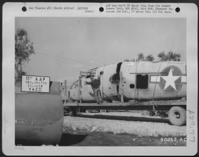 Consolidated > North Africa-Veteran of 21 missions, "Sheepherder" is hauled in to the Reclamation and Salvage Yard aboard mobile float to be dismantled and valuable parts reclaimed for reissue.