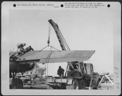 Consolidated > North Africa-With last bolts and connections severed, high outer wing of a B-25 is removed from main inner section with aid of the mobile crane, later to be placed in stock for reissue.