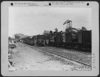 Consolidated > North African natives unload railroad cars containing salvaged French airplane parts which will be cut and baled for shipment and re-use. 28 June 1943.