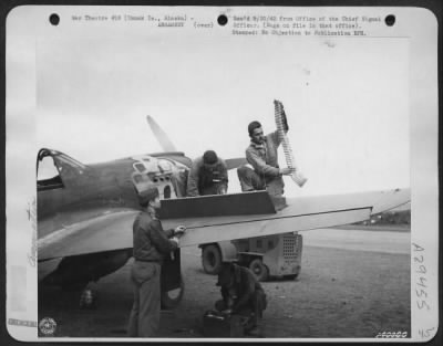 Consolidated > Loading a "Flying Tiger" P-40 with 50 cal. Machine gun bullets is done immediately as ship lands. Lt. James Perryman supervises the loading of the airplane.