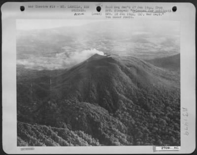 Consolidated > Mt. Langila, a semi-active volcano on New Britain, smoking as American Bombers flew over to blast the beach just before Maj. Gen. Repertus' marines landed.