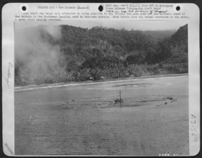 Thumbnail for Consolidated > This small Jap cargo ship attempted to bring supplies to Nip troops, but goes down off the southern coast of New Britain in the Southwest Pacific, sunk by American bombers. Note debris from the vessel scattered in the water, & smoke still hanging