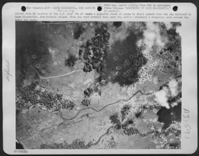 Thumbnail for Consolidated > Direct hits by bombers of the U.S. Army 5th AF cause a gigantic cloud of smoke to whirl upward from the Jap airfield at Cape Gloucester, New Britain Island. Note the bomb craters that scar the entire revetment & dispersal area around the enemy air