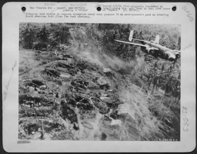 Thumbnail for Consolidated > Cringing Japs huddle in dugouts alongside heavy dual purpose 75 mm anti-aircraft guns as strafing North American B-25 flies few feet overhead.