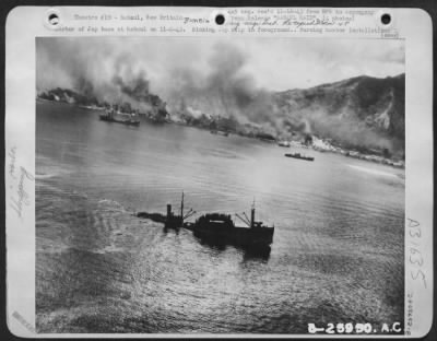 Thumbnail for Consolidated > Harbor of Jap base at Rabaul on 11-2-43. Sinking Jap ship in foreground. Burning harbor installations in background are causing heavy pall of smoke to hang over area. General MacArthur's communique on 11-4-43, reported the harbor at Rabaul, major