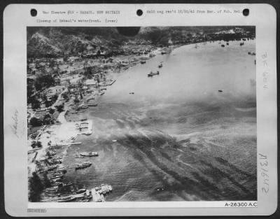 Thumbnail for Consolidated > Closeup of Rabaul's waterfront. Sweeping low across the harbor a Fifth Air Force North American B-25 made this closeup of Rabaul's waterfront. At almost the same moment one of the largest flights of bombers which have attacked the enemy base dropped