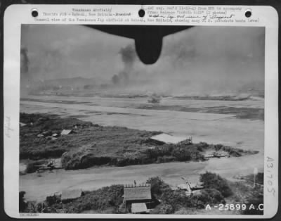 Thumbnail for Consolidated > General view of the Vunakanau Jap airfield at Rabaul, New Britain, showing many U.S. parachute bombs falling on the Jap base (upper left). Smoke in the background is from falling bombs. On October 12, 1943 planes of the United States Army 5th Air