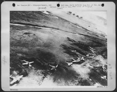 Consolidated > Zero graveyard: From a tree-skimming Fifth Air Force bomber pilots counted 21 Japanese planes in the junk-pile at Vunakanau airdrome;  some of the results of recent air attacks on Rabaul. P.S.: More are burning in the background.