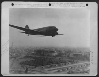 Consolidated > Douglas C-47 with special Venturi attachment spraying DDT over camp area in Manila, Philippine Islands.