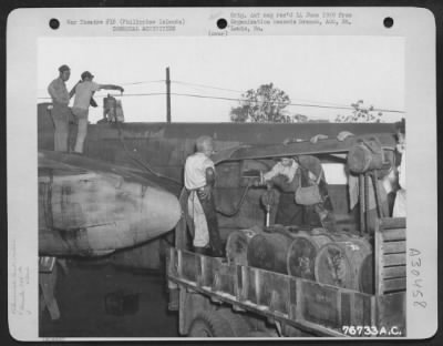 Consolidated > Members of the 886th Operation Co., Chemical Warfare Service (attached to the 42nd Bomb Group) prepare a North American B-25 for smoke screen tests at Palawan, Philippine Islands, in preparation for the invasion of Tarakan, 30 April 1945.