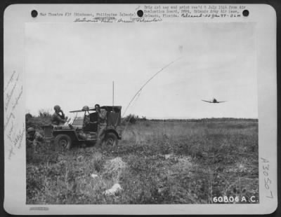 Consolidated > In close air-ground cooperation, it is necessary to have a radio jeep near the target to contact the planes and direct them to the vital spot. In this photo, a SBD light bomber is buzzing the JASCO jeep while ground personnel talks with the pilot