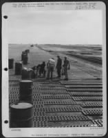 Engineers of the 1913th Aviation Engineer Battalion laying steel matting on airstrip at Clark Field, Luzon, Philippine Islands. 13 June 1945. - Page 1