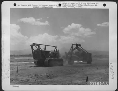 Thumbnail for Consolidated > An area for a new taxiway is roughly leveled with carryalls towed by a caterpillar tractor. The work on this project began 24 April 1945 by th e828th Aviation Engineer Battalion. Clark Field, 30 April 1945. Luzon, Philippine Islands.