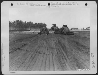 Consolidated > Members of the 1876th Eng. Aviation Battalion smooth and pack the dirt during construction of a new airstrip somewhere in the Philippine Islands. 25 June 1945.