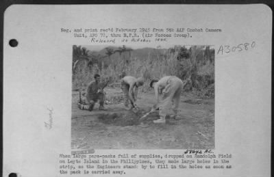 Consolidated > When large para-packs full of supplies, dropped on Randolph Field on Leyte Island in the Philippines, they made large holes in the strip, so the Engineers stands by to fill in the holes as soon as the pack is carried away.