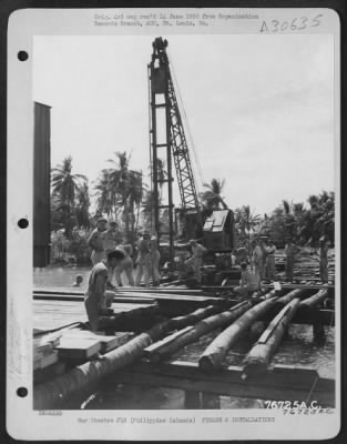 Consolidated > Men of "B" Company of 1876th Engineer Aviation Battalion operate a pile driver during construction of the San Fabian Bridge somewhere in the Philippine Islands.