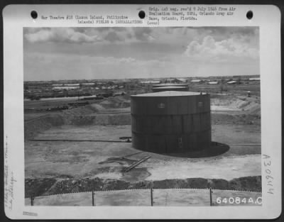 Consolidated > Gasoline bulk plant near Neilson Field, Luzon Island, Philippine Islands. These are temporary tanks; the first is a 10,000 gallon, the second a 5,000 gallon, and the third a 10,000 gallon tank. Note the pipeline leading in and out of the tanks.