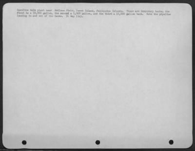 Consolidated > Gasoline bulk plant near Neilson Field, Luzon Island, Philippine Islands. These are temporary tanks; the first is a 10,000 gallon, the second a 5,000 gallon, and the third a 10,000 gallon tank. Note the pipeline leading in and out of the tanks.