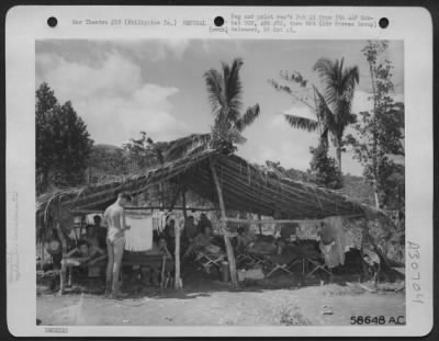 Consolidated > The Recuperation Ward of the hospital at Manawarat on Leyte Island in the Philippines. Here the men with less serious wounds or sicknesses are hospitalized until they are well enough to return to duty. The man at left is making a "grass skirt" from