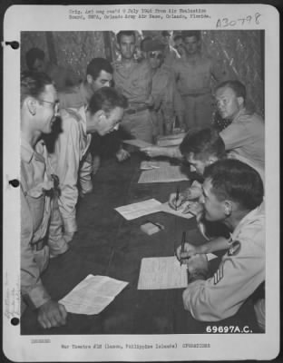 Consolidated > In the classification building of the 22nd Replacement Depot, processing personnel check records of combat troops who are en route to the United States. Manila, Luzon, Philippine Islands, July 1945.
