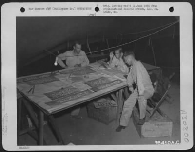 Consolidated > Members of the 1876th Eng. Aviation Battalion work out plans for the Battalion's move to Japan. 23 August 1945.