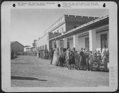 Consolidated > Liberated prisoners of war stand in line to sign up for temporary living quarters in the new Bilibid Prison, Manila, Luzon, Philippine Islands.