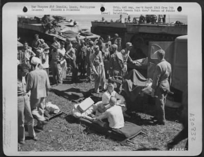 Consolidated > Internees wounded in the taking of a prison camp at Manila, Luzon, Philippine Islands, are loaded on stretchers prior to being placed in waiting ambulances.