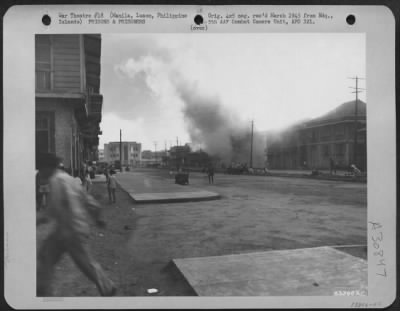 Consolidated > During an intense shelling by the Japanese of the Prison Compound at Santo Tomas, Manila, Philippine Islands, an adjacent building was hit and the entire block burned to the ground. The Japanese used the flames for observation and continued their