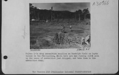 Consolidated > Vultee L-5s drop ammunition supplies on Randolph Field on Leyte Island in the Philippines. Shown here are men rushing out to pick up the cases of ammunition just dropped, and taken them to the ammunition dump.