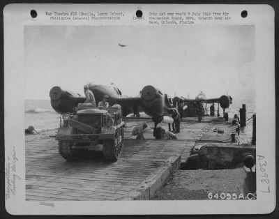 Consolidated > Neilson Field 5th Air Service Area Command Depot #7-Manila, Luzon, Island, Philippine Islands, 8 May 1945. Lockheed P-38 "Lightnings" are shown being brought ashore on barges four at a time, and towed off the barge by a tractor.