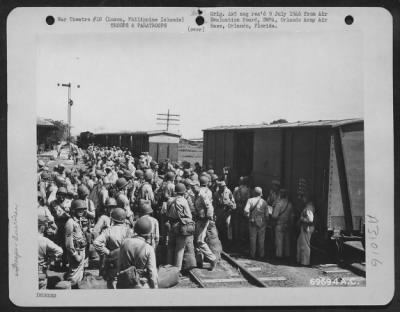 Thumbnail for Consolidated > At the Culi Culi Railroad Station, about three miles from the 22nd Replacement Depot, combat men load their baggage in a freight car for shipment to Clark Field, Luzon, Philippine Islands. The engine (extreme left) will be coupled to the baggage car