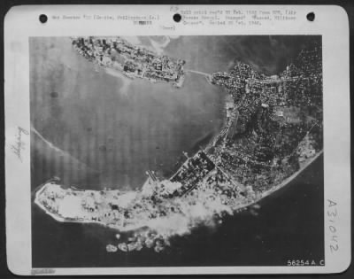 Consolidated > Cavite, Philippine Islands-Cavite naval base, once a major American naval installations, is blasted by planes of the 13th AF during attacks on the Manila Bay area. Huge columns of smoke rising skyward testify to the raiders' accuracy.