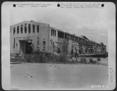 Consolidated > Four large holes and a heavily damaged roof were the result of four direct bomb hits on Pier II, Cebu City. The holes were approximately 10 by 15 feet in the floor of the building. Cebu Island, Philippine Islands. May 1945.