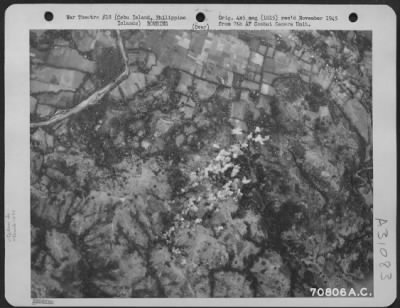 Consolidated > Bombs, dropped from 494th Bomb Group Consolidated B-24 "Liberators," burst on the target-a Japanese bivouac area in a partially wooded section about six miles west of Cebu City, Cebu Island in the Philippines. 25 March 1945.