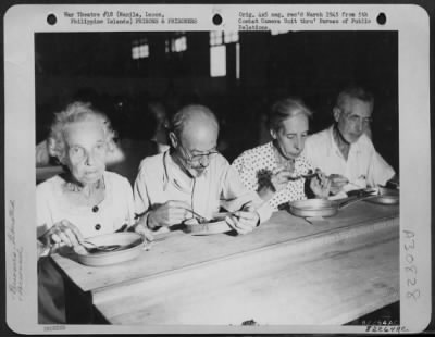 Consolidated > Prisoners Liberated From A Prison Camp In Manila, Luzon, Phillippine Islands Eat Their First Square Meal In Over Three Years Of Jap Imprisonment.  Left To Right, Mr. & Mrs. H. W. Widdoes, A Missonary In Manila For Forty-Two Years And Originally From Sevas
