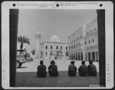 Thumbnail for Consolidated > Yanks on a short leave to Bengasi, Cirenaica, Libya, sit in the shade of a building arch facing one of the public squares of the native city. This community suffered hundreds of aerial bombardments in the to-and-fro desert warfare of North Africa.