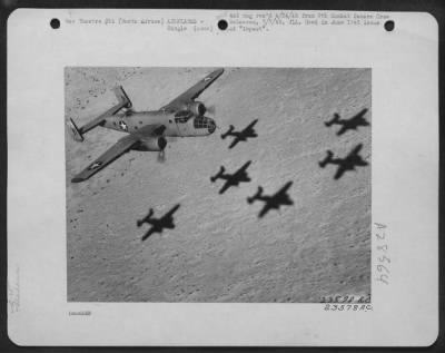 Consolidated > North American B-25  "Mitchell" flys over North African desert enroute to the target for the day. Note shadows cast by preceding formation. North Africa.
