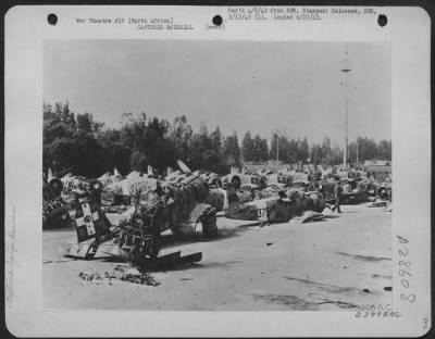 Consolidated > North Africa-Wrecked Axis aircraft, victims of bombing and strafing by the USAAF, lay piled up on airdrome. Soon expert salvage crews will denude the wreckage of any usable parts, the remainder going into the furnace to be used against Hitler