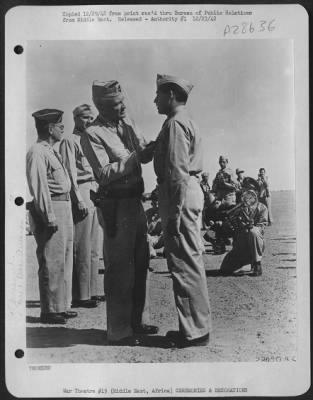 Consolidated > Receiving the order of the Purple Heart for wounds received while engaged with enemy fighter planes is 1st Lt. Meech Tasquah, of Walters, Okla. He is shown being decorated by the Commanding General of U.S. Army Forces in the Middle East at an
