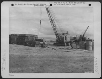 Consolidated > Civilian labor piles steel matting to be used in the construction of an airfield at Valmy, Oran, Algeria. 26 March 1943.