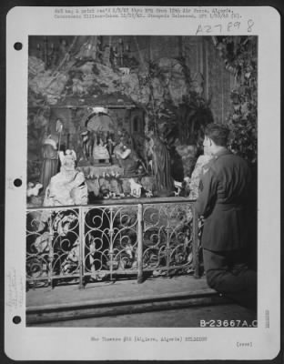 Consolidated > Sgt. John R. Fitzgerald, Aerial Engineer of the 12th Air Force, from Kansas City, Mo., is shown praying at the crib of the Christchild in St. Charles Cathedral in Algiers during a mass held for the soldiers in North Africa.