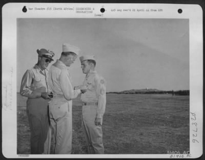 Consolidated > S/Sgt. Francis E. Donahue, 416 N. Tacoma Ave., Indianapolis, Indiana, bombardier of a USAAF North American B-25 Mitchell bomber of Maj. Gen. Jimmy Doolittle's Bomber Command, is shown receiving the Distinguished Flying Cross from Lt. Gen. Carl A.