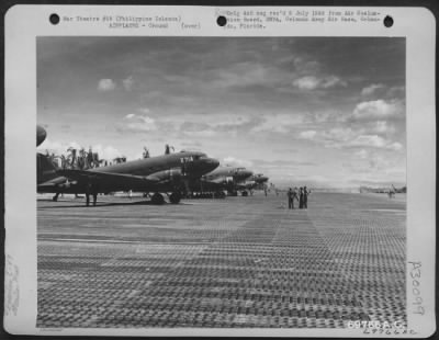 Consolidated > Douglas C-47s are parked on the line at an airstrip somewhere in the Philippine Islands.
