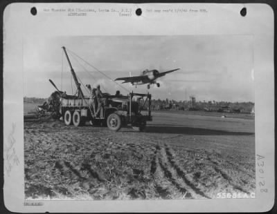 Consolidated > Hauling away wrecked plane while another takes off. Tacloban, Leyte Is., P.I.