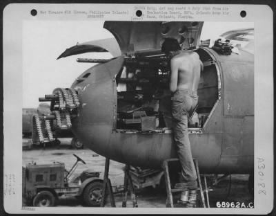 Thumbnail for Consolidated > An armorer cleans the 50 cal machine guns in the nose of a North American B-25 of the 500th Bomb Squadron, 345th Bomb Group, parked on Clark Field, Luzon, Philippine Islands. 25 June 1945