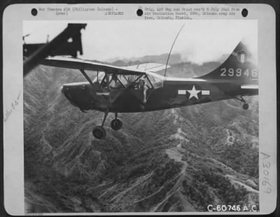 Consolidated > When Air Liaison Officers Failed To Reach Observation Areas From Which They Could Direct Bombers To Targets; L-5S Were Used To Direct The Air Attacks.  While Bombers Circle The Mountians Above, This L-5 Is Preparing To Mark The Target With Smoke.  Philipp