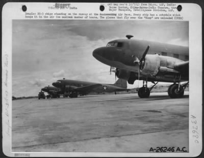 Consolidated > Douglas DC-3 ships standing on the runway at the Air Base. Every ship has a schedule which keeps it in the air the maximum number of hours. The planes that fly over the "Hump" are unloaded a few minutes after landing and take off again for another